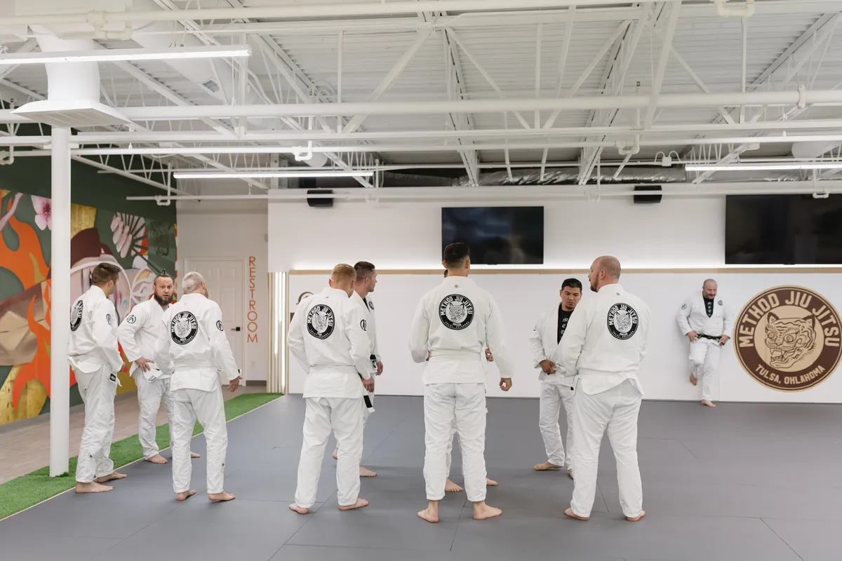 Adult students in white gis training on the mat at Method Jiu-Jitsu gym in Tulsa, Oklahoma