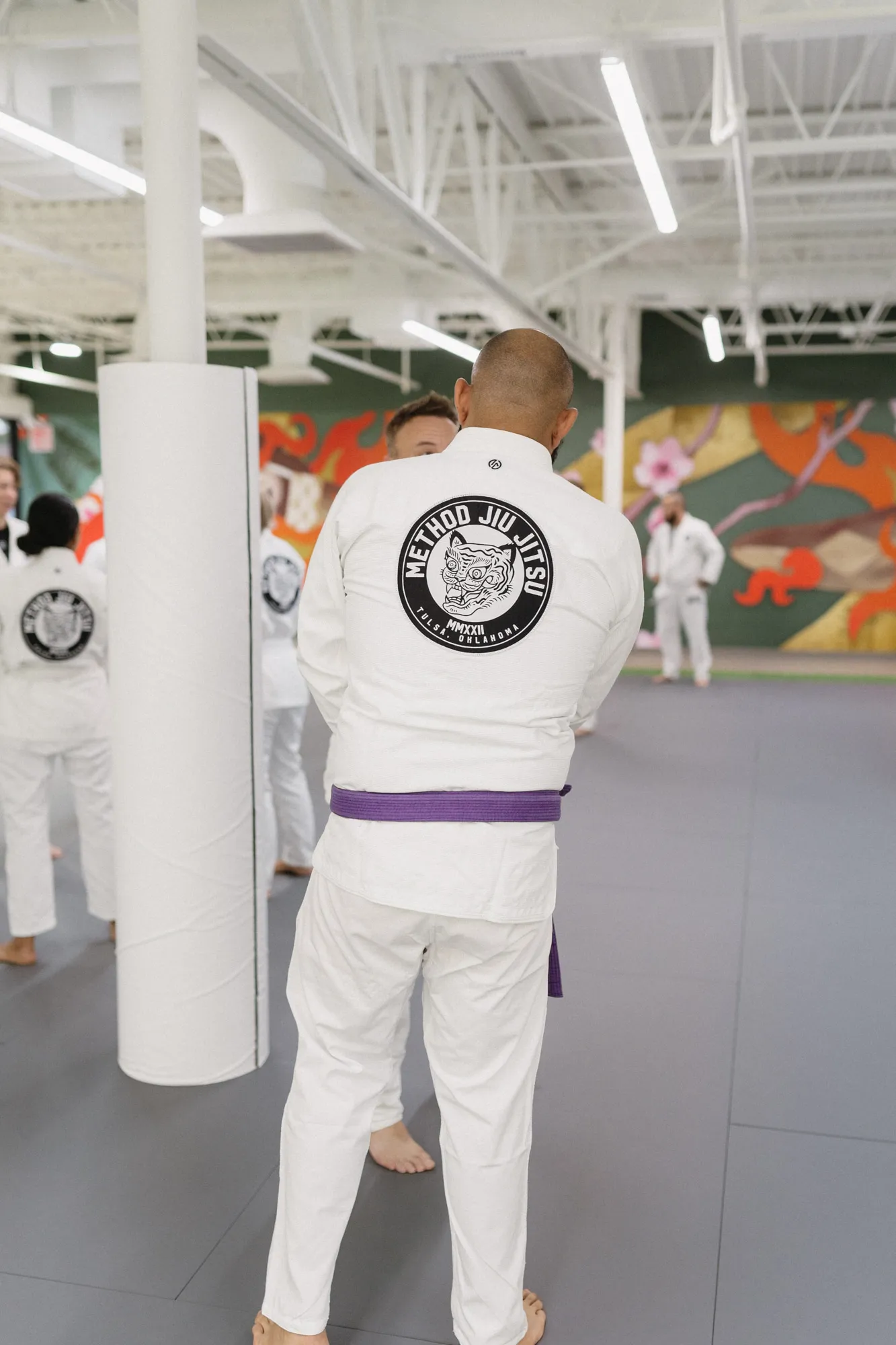 Students in white gis training together during a jiu-jitsu class at Method Jiu-Jitsu in Tulsa, Oklahoma