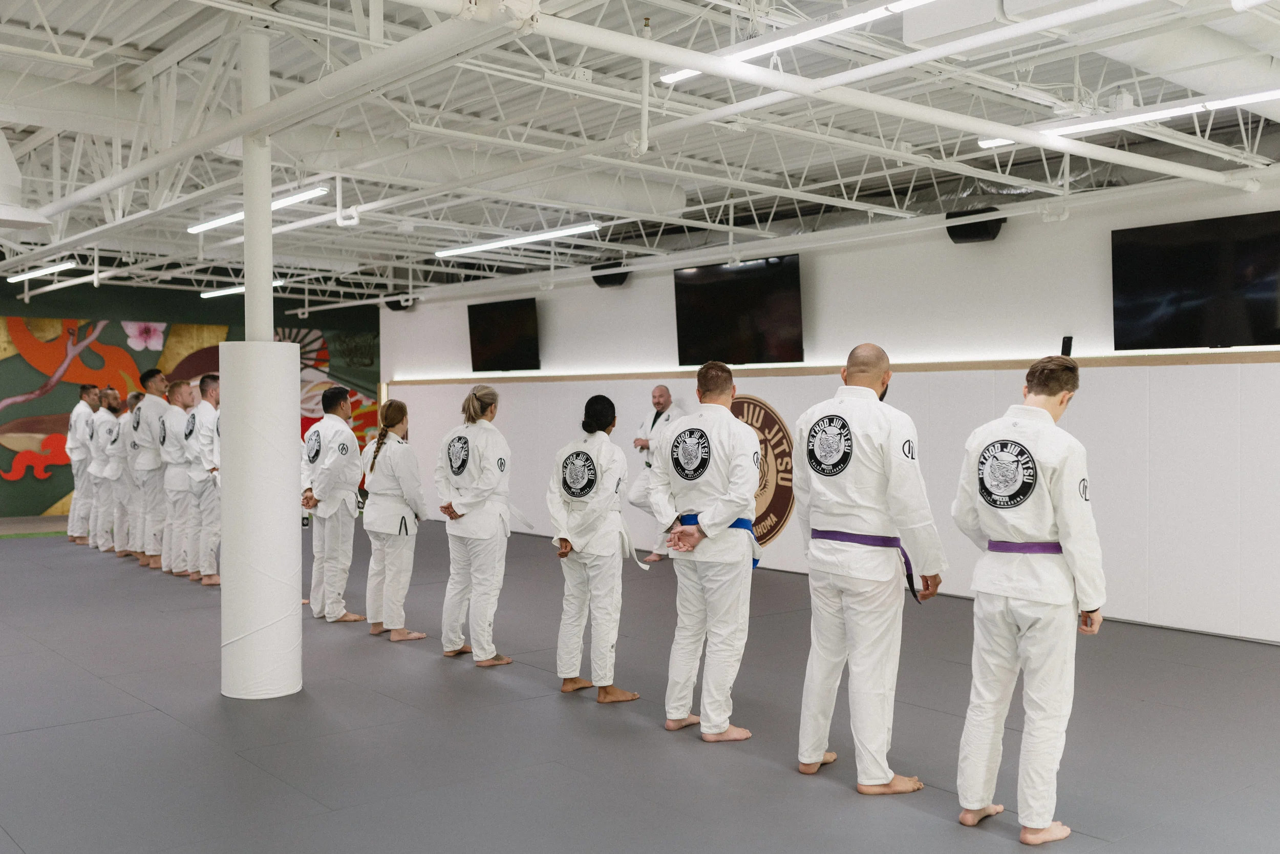 Students lined up in white gis during a Brazilian Jiu-Jitsu class at Method Jiu-Jitsu in Tulsa, Oklahoma