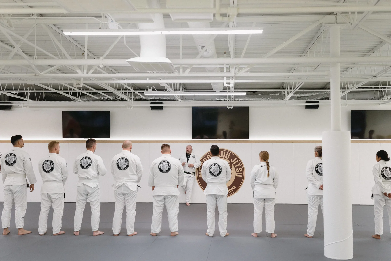Students lined up in white gis during a jiu-jitsu class at Method Jiu-Jitsu in Tulsa, Oklahoma