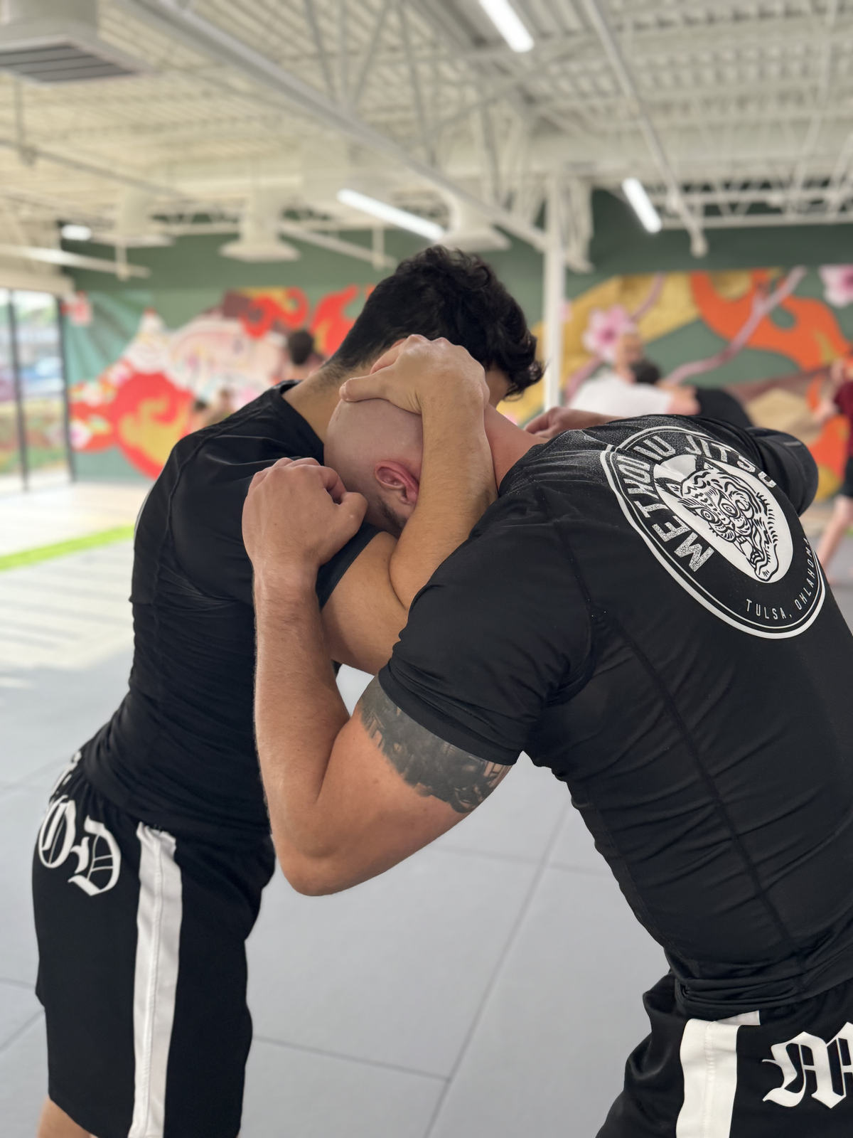 Two grapplers training no-gi submission grappling on the mats at Method Jiu-Jitsu in Tulsa